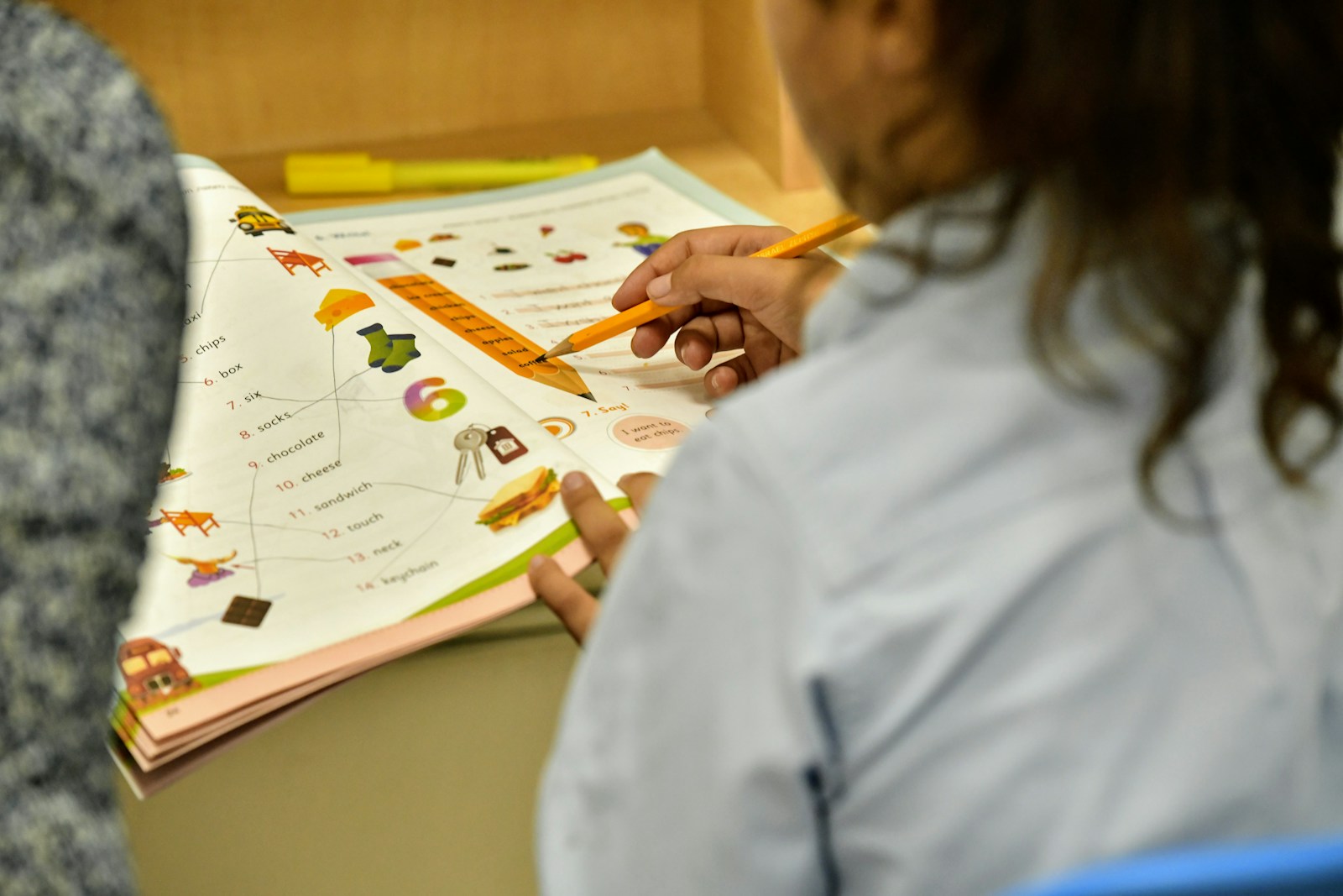 a woman is holding a pencil and looking at a book